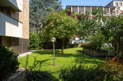 a garden in front of a building with a pole in the grass at Tranquillo bilocale vicino al centro storico in Bolzano