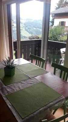 a table with a green table cloth on it with a window at Relax Home Fie' allo Sciliar - Alpe di Siusi Val Gardena in Fiè