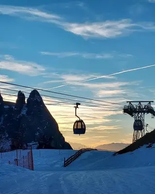 a ski lift in the snow with a mountain in the background at Relax Home Fie' allo Sciliar - Alpe di Siusi Val Gardena in Fiè