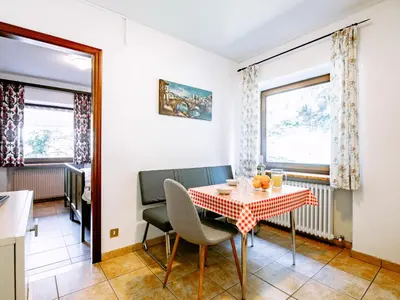 a dining room with a table and chairs and two windows at Apartment Cesa Minach-2 by Interhome in Alba di Canazei