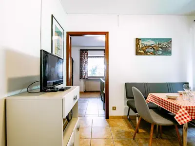 a living room with a television and a dining room table at Apartment Cesa Minach-2 by Interhome in Alba di Canazei