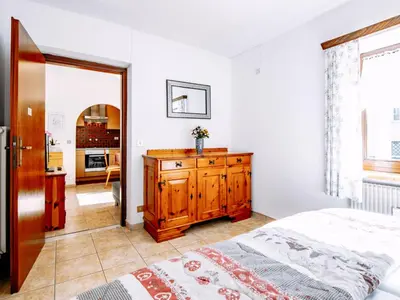 a bedroom with a bed and a wooden dresser at Apartment Cesa Minach-3 by Interhome in Alba di Canazei