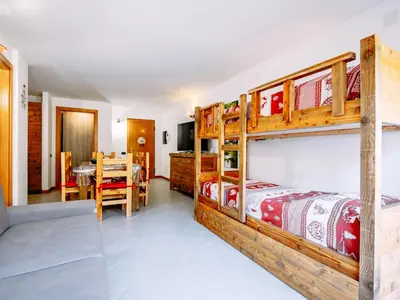 a bedroom with two bunk beds and a dining room at Apartment Torrita di Canazei by Interhome in Alba di Canazei