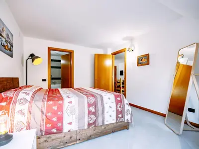 a bedroom with a bed and a mirror at Apartment Torrita di Canazei by Interhome in Alba di Canazei