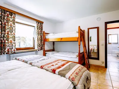 a bedroom with two bunk beds and a mirror at Apartment Cesa Minach-1 by Interhome in Alba di Canazei
