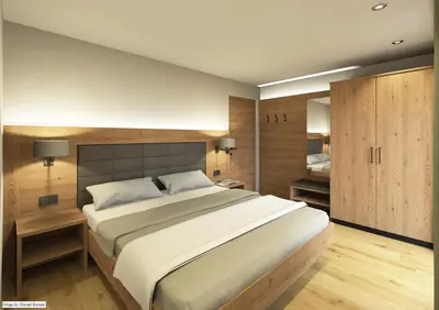 a bedroom with a large bed and a bathroom at Appartements Pedescin in Ortisei