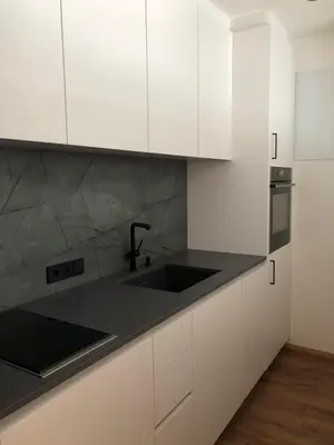 a kitchen with white cabinets and a sink at Appartements Pedescin in Ortisei