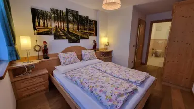 a bedroom with a bed and a desk and a painting at Alex in Campitello di Fassa