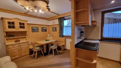 a kitchen with a table and a dining room at Alex in Campitello di Fassa