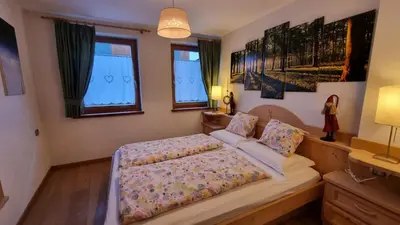 a bedroom with a bed and two windows at Alex in Campitello di Fassa