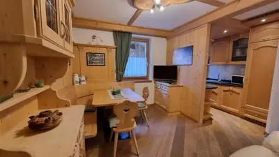 a kitchen with a table and a desk in a room at Alex in Campitello di Fassa