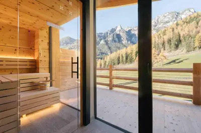 a large glass door in a wooden room with a view at Cyprianerhof Dolomit Resort in Tires