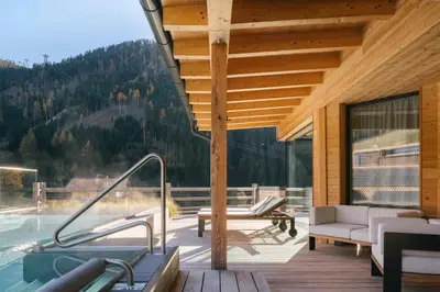 a wooden deck with a hot tub on a house at Cyprianerhof Dolomit Resort in Tires