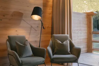 two chairs and a lamp in a living room at Cyprianerhof Dolomit Resort in Tires