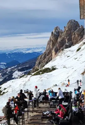 a group of people sitting at tables on a snow covered mountain at App. Lino nel cuore di Ortisei - casa dell'800 in Ortisei