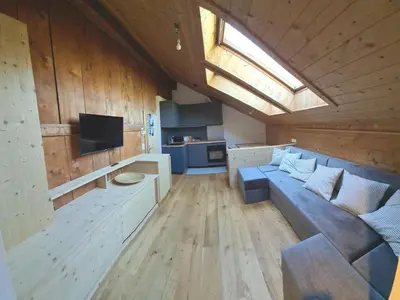 a large living room with a couch and a tv at App. Lino nel cuore di Ortisei - casa dell'800 in Ortisei