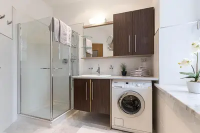a bathroom with a shower and a washing machine at Appartment Lissi in Merano