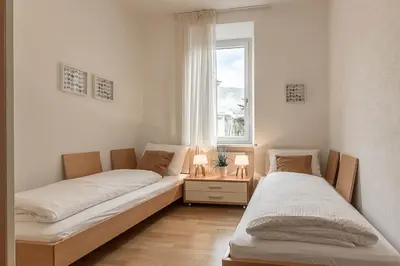 two beds in a room with a window at Appartment Lissi in Merano