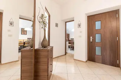 a hallway with a wooden door and a vase with flowers in it at Appartment Lissi in Merano