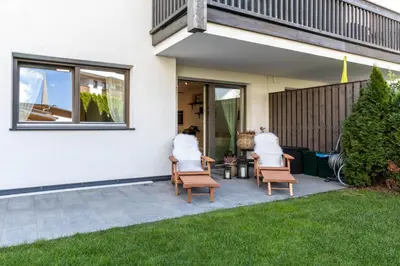 two people sitting in chairs outside of a house at Casa Fiammetta in Brunico