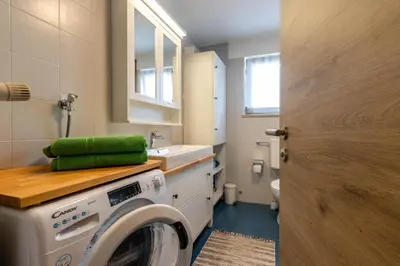 a laundry room with a washing machine and a sink at Casa Waldheim in Brunico