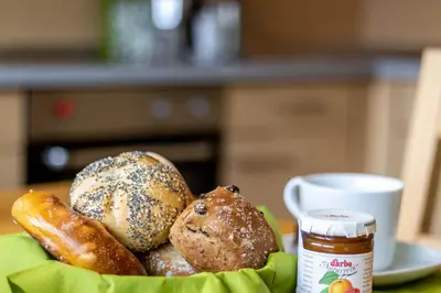 a basket filled with bread and a jar of jam at Casa Waldheim in Brunico
