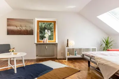 a bedroom with a bed and a table and a window at Central Attic - Castle view in Brunico