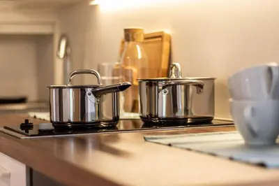 two pots and pans sitting on a kitchen counter at Central Attic - Castle view in Brunico