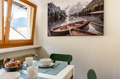 a table with a bowl of food and a picture of a boat at Central Attic - Castle view in Brunico