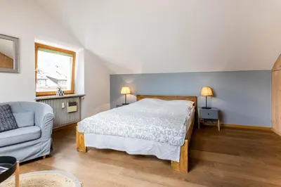 a bedroom with a large bed and a couch at Central Attic - City view in Brunico