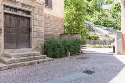 a building with a brown door and stairs on a street at Central Attic - City view in Brunico