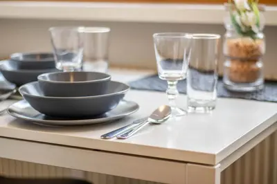 a table with bowls and glasses on top of a counter at Central Attic - City view in Brunico