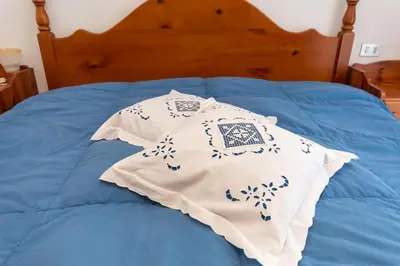 a bed with two pillows on top of it at Casa Blue Sky in Moena
