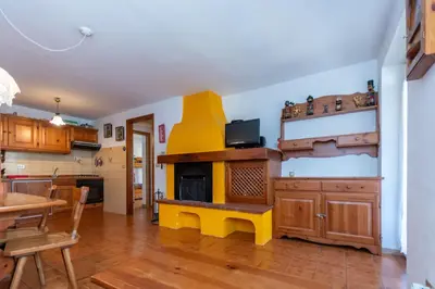 a kitchen with a yellow bench in front of a fireplace at Casa Blue Sky in Moena