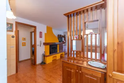 a kitchen with a staircase and a living room at Casa Blue Sky in Moena