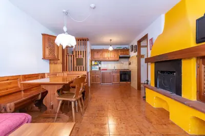 a kitchen with a table and a dining room at Casa Blue Sky in Moena