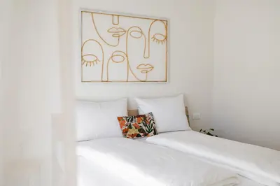 a bedroom with a white bed with a picture on the wall at Italyescapes Maia in Merano