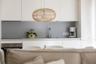 a kitchen with white cabinets and a table with chairs at Italyescapes Maia in Merano