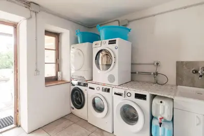 two washing machines and a washer and dryer in a laundry room at Dolomitihouse FAGHER in Fiera di Primiero