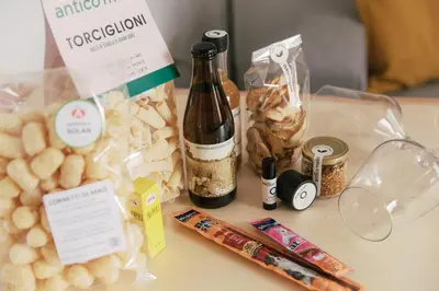 a table with a bottle of wine and some food at Dolomitihouse FAGHER in Fiera di Primiero