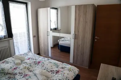 a bedroom with a bed and a large mirror at Casa Ricky in Bolzano