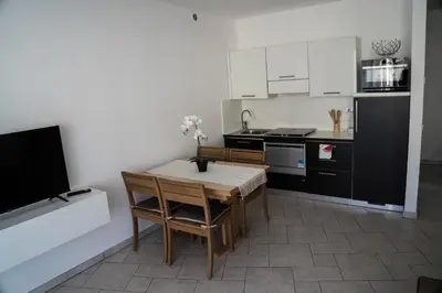 a kitchen with a table and chairs and a kitchen with a tv at Casa Ricky in Bolzano