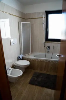 a bathroom with a toilet and a tub and a sink at Casa Ricky in Bolzano