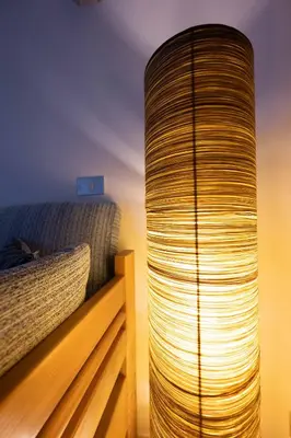 a large cylindrical lamp sitting next to a bed at Cesa te Val in Vigo di Fassa