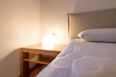 a bedroom with a bed and a nightstand with a lamp at Cesa te Val in Vigo di Fassa