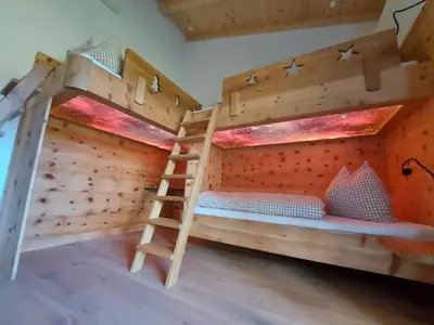 a bunk bed with a ladder in a room at SchartnerAlm in Collalbo