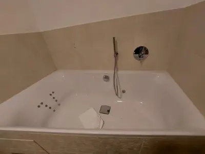 a white bath tub with a faucet in a bathroom at SchartnerAlm in Collalbo