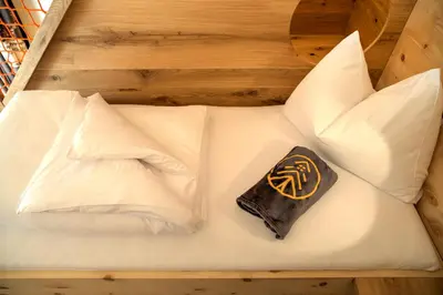 a bed with white pillows and a chocolate bar on it at SchartnerAlm in Collalbo