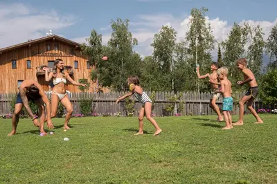 a group of people playing with a ball in a yard at SchartnerAlm in Collalbo