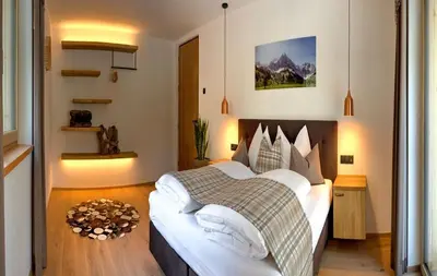 a bedroom with a large bed with white pillows at SchartnerAlm in Collalbo